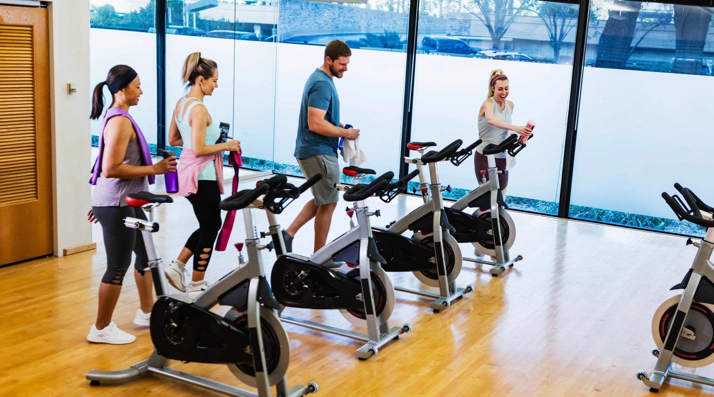 Young adults preparing for a stationary cycling class